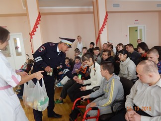 Инспектор ДПС О.А. Турченков раздаёт детям подарки